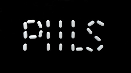 White pills on a black background inscription made of pills. Medical preparations. Dietary supplements and medicines. Do not be ill.
