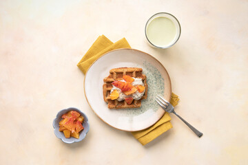 Vegan, gluten free waffles with pudding, oranges and green milk on bright background. Healthy meal, tasty homemade breakfast.