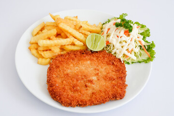 pork schnitzel with fries isolated on white background.