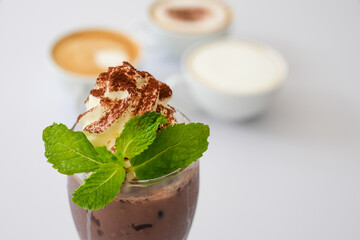 Glass of Iced chocolate with whip cream on white table.