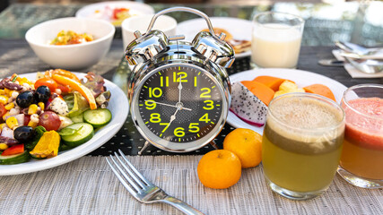 Selective focus of alarm clock which the  concept of proper nutrition. Diet intermittent fasting image - obrazy, fototapety, plakaty