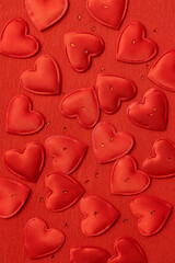 Vertical image of many little red hearts on the paper background.Monochrome image