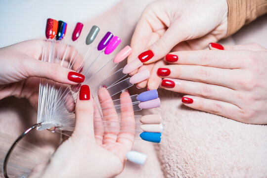 Close up image of manicurist showing  color palette of nail services. Focus on part of palette.