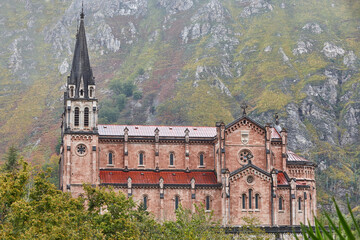Fototapeta na wymiar Picturesque red stone basilica and mountains in Covadonga. Cangas, Asturias