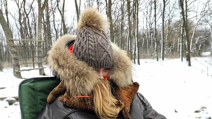 The girl is sitting in the winter forest.