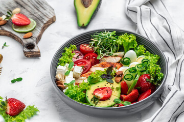 Ketogenic diet food, chicken fillet, quinoa, avocado, avocado, feta cheese, quail eggs, strawberries, nuts and lettuce. healthy meal concept, top view