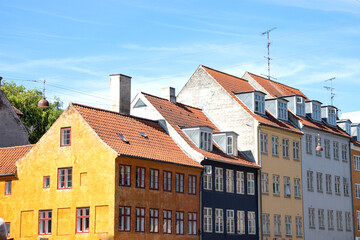 Fototapeta na wymiar Copenhagen, Denmark-Christianshavn canal, colorful facades of old houses. King Christian's Harbour is a neighbourhood in Copenhagen. Real estate investment. Rent an apartment. Expensive housing. 