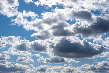 Light and dark fluffy clouds in the sky. Evening dark sky. Trendy sky background for your photos