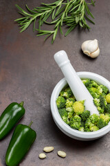 Broccoli in mortar and pestle.