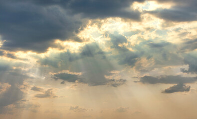 Naklejka na ściany i meble The sun's rays break through dense clouds in even rows.