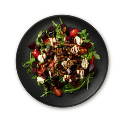 Raw green beet and arugula salad with blue cheese on black plate isolated on white.