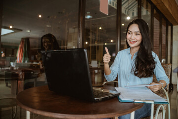 Fototapeta premium Freelancer woman working using laptop with thumbs up hand gesture