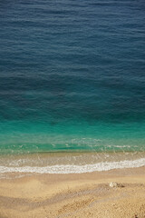 beach with yellow sand and blue sea on a sunny day