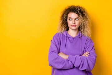 Photo of young attractive lady folded hands curious look empty space isolated over yellow color background