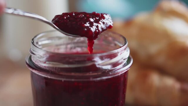 Raspberry jam with fresh baked croissants and milk, close-up. Healthy food concept.