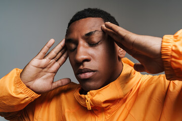 Young black man with headache rubbing his temples