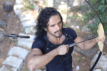 Futuristic knight holding long bow in the forest