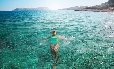 Smiling woman lying on her back floating in the sea water, relaxing on vacation, Travelling tour in Turkey