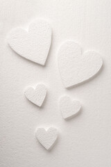 Pattern of white styrfoam hearts on the sheet of a white styrfoam with a copy space. Valentine's day background.