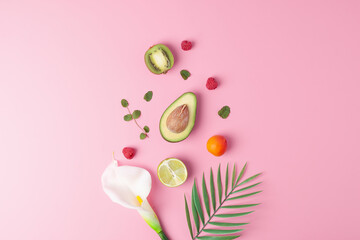 Summer fruit composition. Creative tropical background made from fresh fruits and palm leaves on pink. Flat lay, copy space.