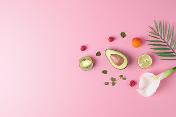 Summer fruit composition. Creative tropical background made from fresh fruits and palm leaves on pink. Flat lay, copy space.