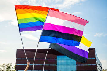 Rainbow pride flag, non-binary flag and genderfluid flag. LGBT community waving flags on a LGBT pride parade
