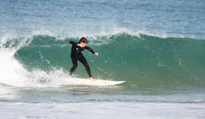 Happy teenager surfing in the Atlantic Ocean