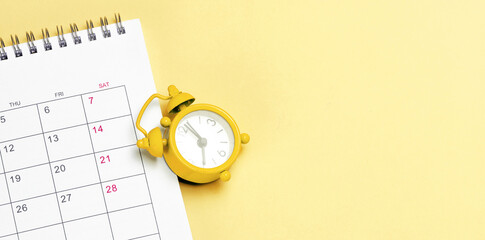 Yellow alarm clock and calendar on yellow background. Template Copy space for text. mock-up