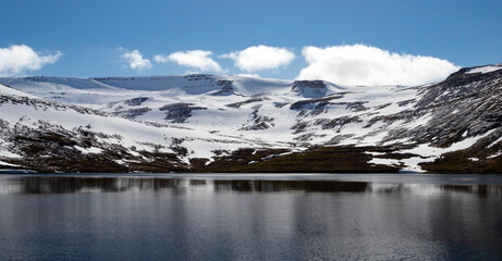 Beautiful mountains with snow picks and turquoise water of Atlantic ocean. Westfjords, Iceland. Horizontal banner.