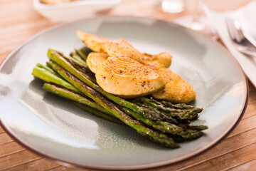 cooked dish. Chicken nuggets with green asparagus on plate