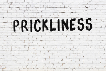 White wall with black paint inscription prickliness on it
