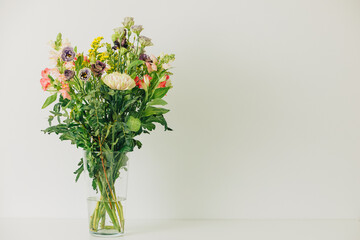 Fototapeta na wymiar Beautiful bouquet of flowers in a vase. Bouquet of chrysanthemum, alstroemeria, goldenrod, snapdragon, lisianthus and eucalyptus parvifolia. bouquet of flowers on white background. 