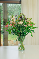 Beautiful flowers in a vase on the table. flowers at home. Deliver fresh flowers 