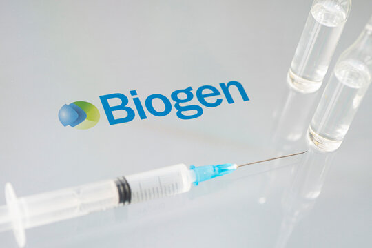Vials of liquid on a white table and the logo of a large pharmaceutical company.