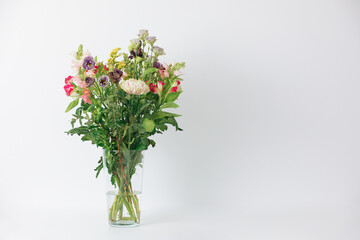 Fototapeta premium Beautiful bouquet of flowers in a vase. Bouquet of chrysanthemum, alstroemeria, goldenrod, snapdragon, lisianthus and eucalyptus parvifolia. bouquet of flowers on white background. 