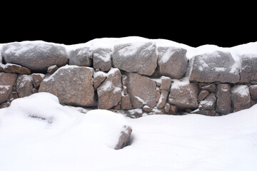 natural stone in snow isolated on black background