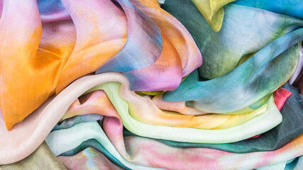 Multicolored silk scarves close-up. A set of silk fabrics.