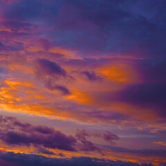 Purple orange sunset. Evening sky with clouds. Beautiful colorful sky background with space for design. Magic fantasy skies.