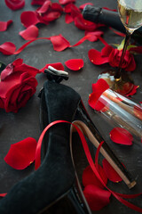 Romantic valentines day rendezvous with red roses and black stilettos. Vertical background for love...