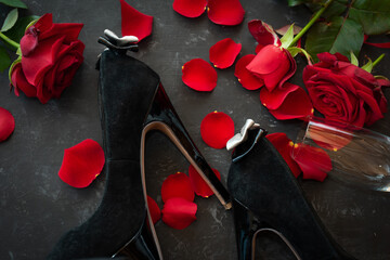 Romantic valentines day rendezvous with red roses and black stilettos. Background for love and...