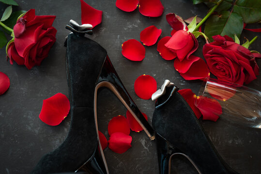 Romantic valentines day rendezvous with red roses and black stilettos. Background for love and special moments. Top view.