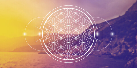 Flower of life - the interlocking circles ancient symbol in front of blurry photo background.