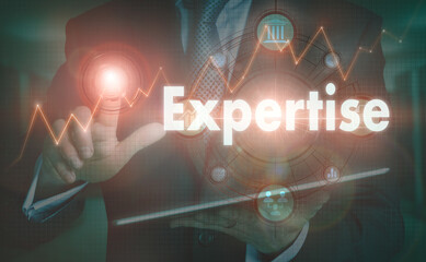 A businessman operating a computer display with a Expertise business word concept on it.