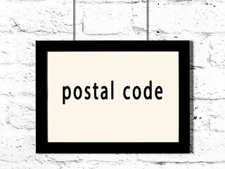 Black frame hanging on white brick wall with inscription postal code - obrazy, fototapety, plakaty