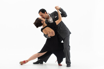 Couple of professional tango dancers in elegant suit and black dress with an open back pose in a...