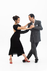 Couple in elegant clothes dancing tango on white background