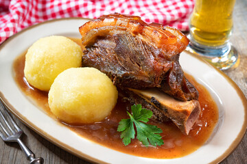 Roast pork shoulder with dumplings and beer