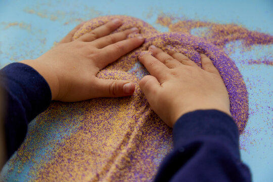 Baby Hands Play With Colorful Sand. Child Fine Motor Skills Development. Creative Kids Occupation. View From Above.