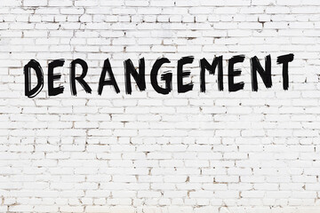 White wall with black paint inscription derangement on it