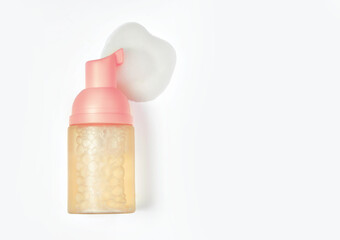 Top view of  jar of facial mousse and smear of  this product, isolated on white background